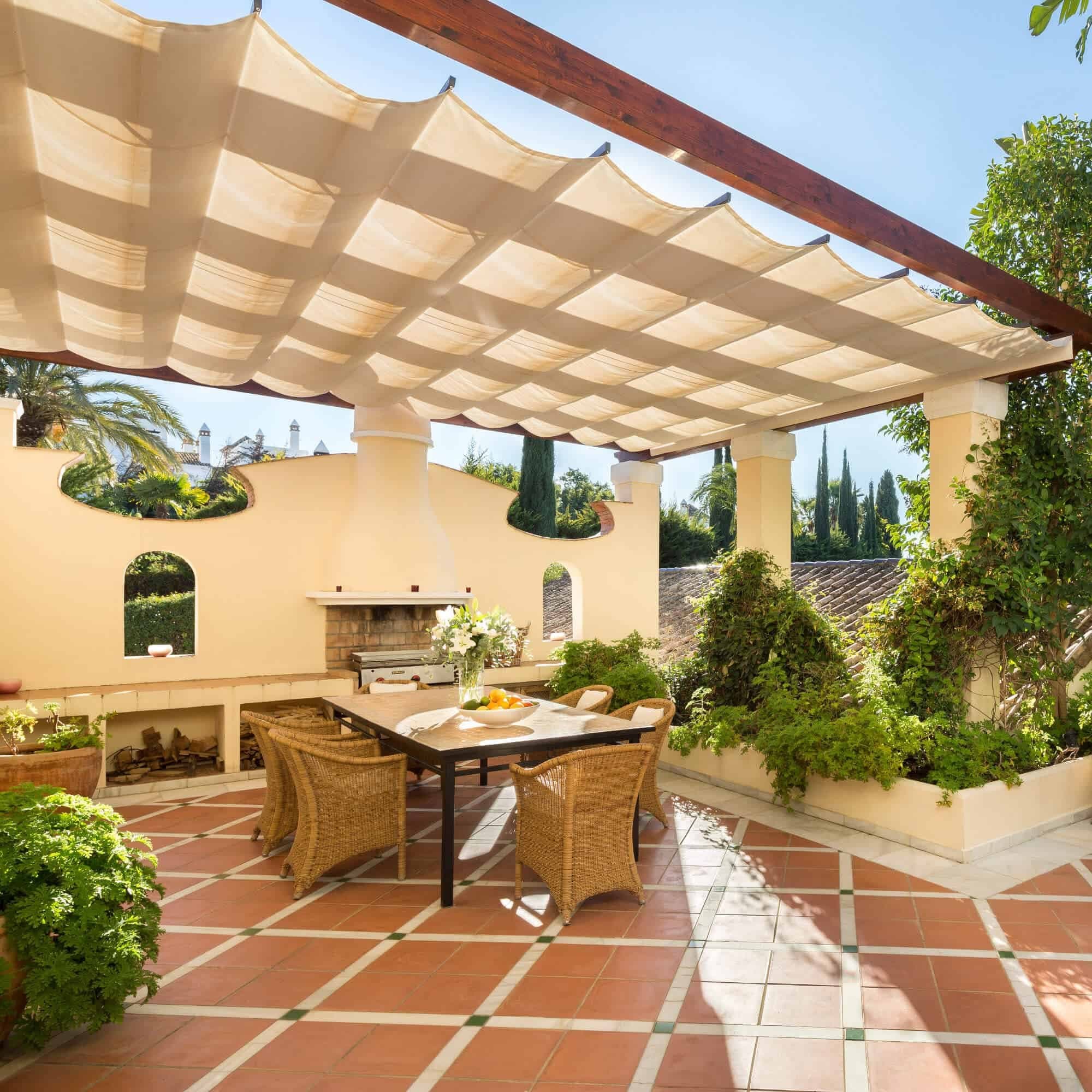 Table set beneath the pergola of a villa in the collection